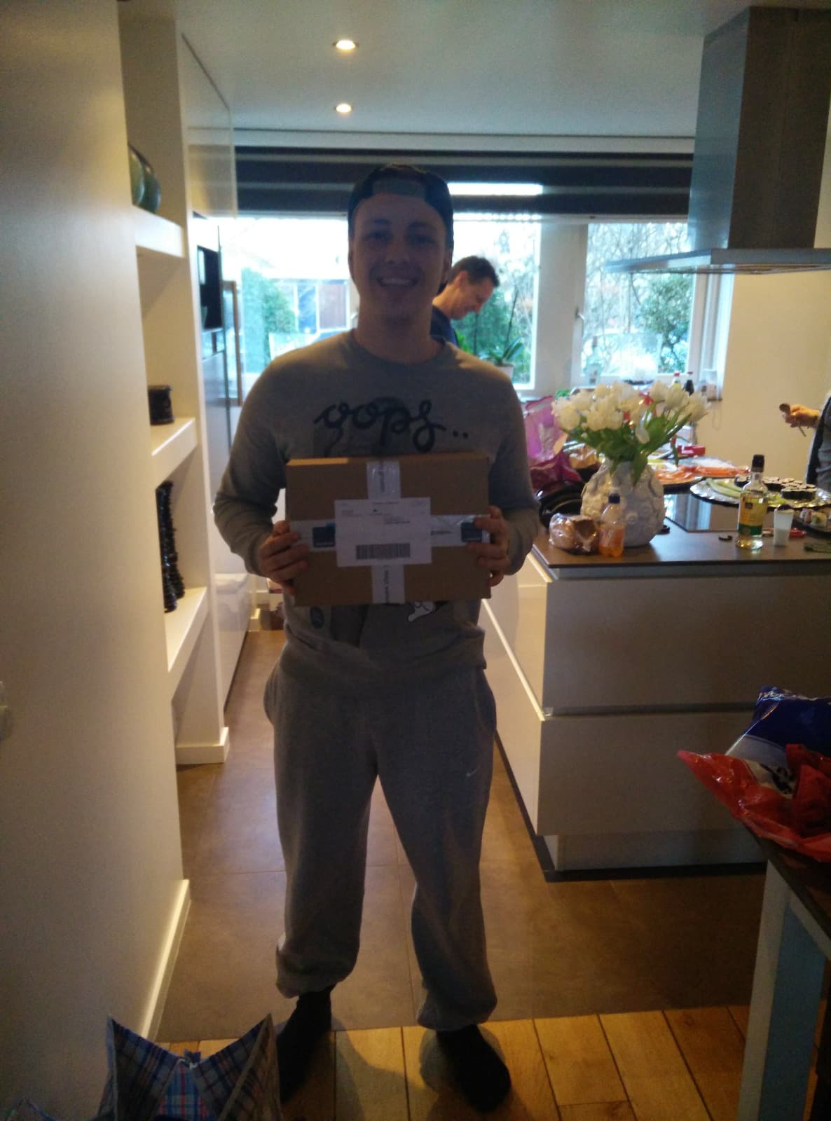 Justin Regterschot holding a package in his kitchen